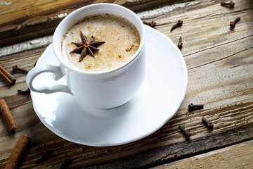 Indian masala chai tea. Spiced tea with milk on dark wooden table. Selective focus, horizontal with copy space.Sunlight.