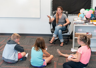 Students sitting on the floor in classroom at STEAM summer camp