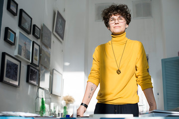 Woman with curly brown hair working in a studio office