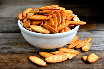 Cracker cookies in a white ceramic bowl on a wooden table.Cracker cookies in a white ceramic bowl on a wooden table.