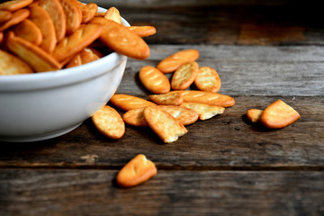 Cracker cookies in a white ceramic bowl on a wooden table.Cracker cookies in a white ceramic bowl on a wooden table.