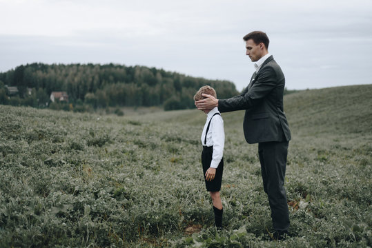 Man closing boy eyes with hands