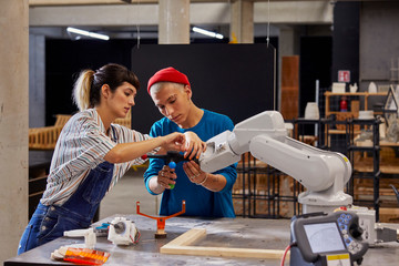 Classmates Working With Robotic Equipment At Desk