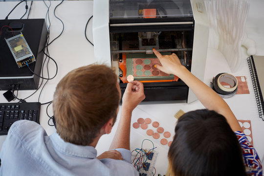 Teacher And Student Working With 3D Printer