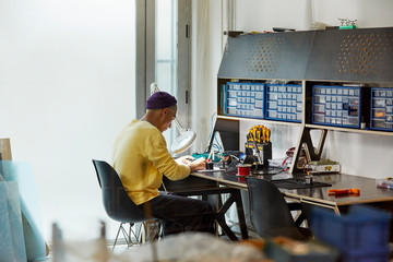 Engineer Working On Electronic Device At Desk