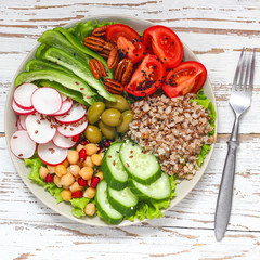 Hummus platter with assorted snacks. Hummus in bowl, vegetables sticks, chickpeas, olives. Plate with Middle Eastern/Mediterranean meze. Party/finger food. Top view. Vegetables, hummus dip,copy space