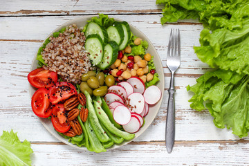 Hummus platter with assorted snacks. Hummus in bowl, vegetables sticks, chickpeas, olives. Plate with Middle Eastern/Mediterranean meze. Party/finger food. Top view. Vegetables, hummus dip,copy space