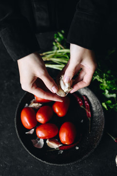 Crop hands putting garlic into bowl