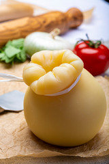 Italian provolone or provola caciocavallo hard cheese in teardrop form served on old paper close up