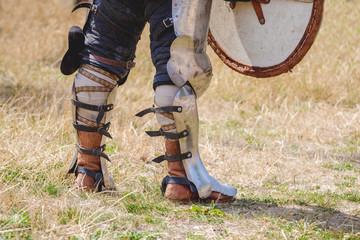 Knight's legs in combat armor. The knight waits for the start of the battle_