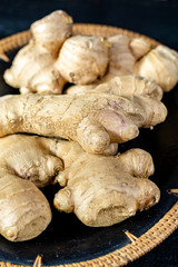 Fresh ginger roots close up on black wooden background