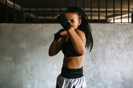 Kickboxing woman training in old gym
