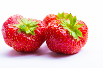 Three red ripe strawberries isolated on white background
