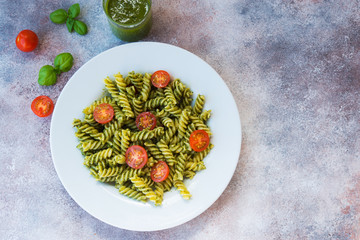 Italian pasta fusilli with green pesto sauce and Parmesan. Horizontal orientation with copy space