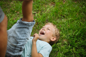 Laughing boy lying on green grass