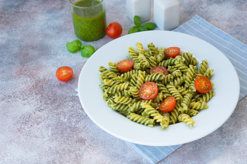 Italian pasta fusilli with green pesto sauce and Parmesan. Horizontal orientation.