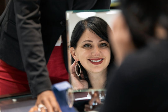 Jewelry: Woman Checking Reflection Of Earrings In Mirror