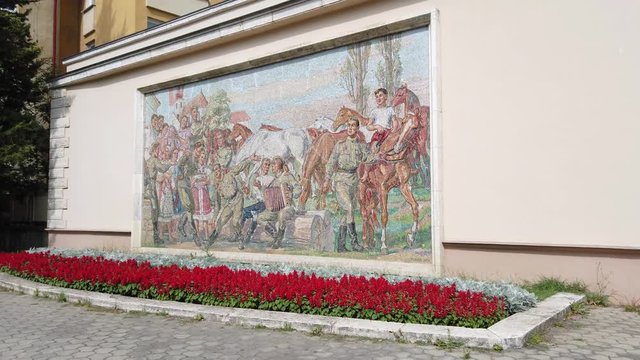 Pan shot of a red army mosaic in the streets.