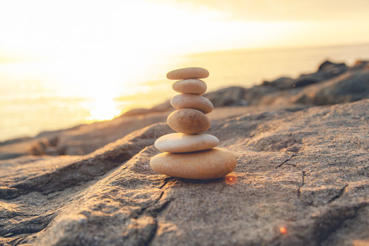 Stones pyramid on the seashore at sunset