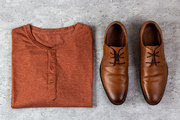 Flat lay composition of male shirt and shoes on concrete background