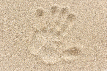 Fototapeta na wymiar Huella de mano en arena de playa.