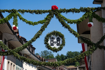 Obraz premium The tower of brugg with fresh pine decoration in old town Brugg on the 4th of july at Jugendfest Brugg 2019.