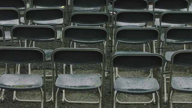 rows of empty seats in stadium on a rainy day