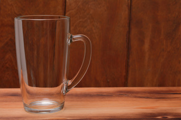 An empty glass cup for tea and coffee on a wooden table.