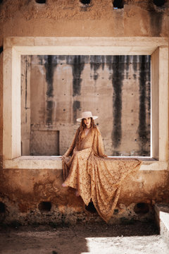 Elegant female in long dress on window