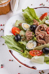 Fresh salad with iceberg lettuce,tomatoes,eggs,canned tuna and olives