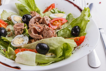Fresh salad with iceberg lettuce,tomatoes,eggs,canned tuna and olives