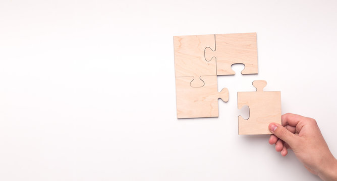 Woman creating picture with missing piece of wooden puzzle