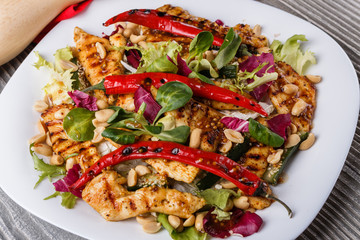 Mexican salad with hot pepper chiken fillet lettuce on plate