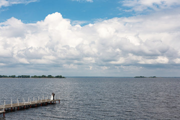 Obraz premium bride and groom walking on the bridge near the river.wedding day. bridal walk outdoors.portrait of newlyweds in nature