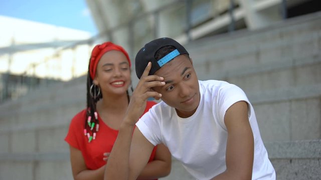 Emotional teenage girl telling different stories, boy shocked by talkativeness