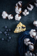 slice of blueberry scone on dark background