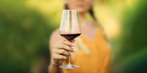 Red wine glass in the hand of a Woman - Drink and Taste Wine Background Banner - Selective Focus
