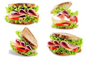 Sandwich with whole grain bread, salad, cheese, tomato and ham on a white isolated background