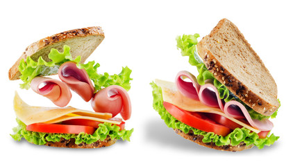 Sandwich with whole grain bread, salad, cheese, tomato and ham on a white isolated background