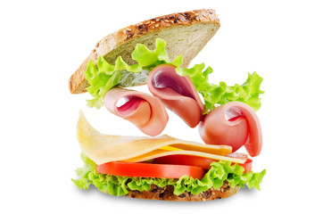 Sandwich with whole grain bread, salad, cheese, tomato and ham on a white isolated background
