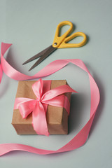Process of packaging gift boxes. Thanks gifts. Wedding presents. Pink ribbon and yellow scissors. 