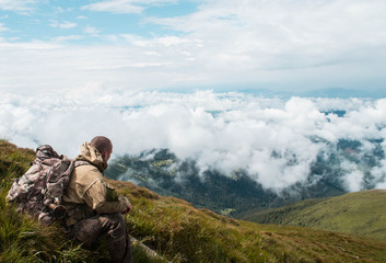 A man sits on top of a mountain