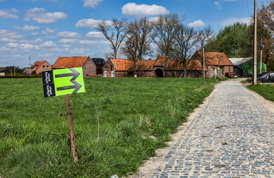 Templeuve,France- April 5, 2014: Image of route indicators located on the side of the cobblestone road near the Moulin de Vertain during Paris-Roubaix cycling race.