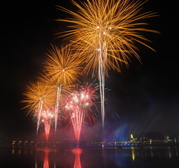 Fogo de artifício no céu em cores vermelho, verde e laranja