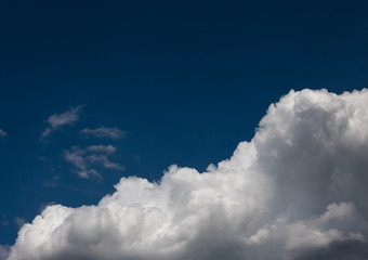 Naklejka na ściany i meble Fluffy white summer clouds isolated on indygo blue sky.