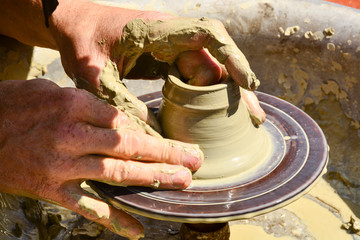 Craftsman artist making craft, pottery, sculptor from fresh wet clay on pottery wheel, selected...