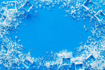 Pile of ice cubes frame on blue bar desk background top view mock up