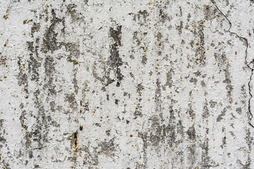 texture of an old wall with uneven cracked stucco, dirty surface of the exterior painted wall