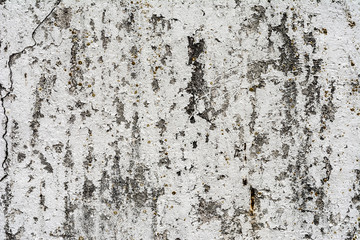 texture of an old wall with uneven cracked stucco, dirty surface of the exterior painted wall