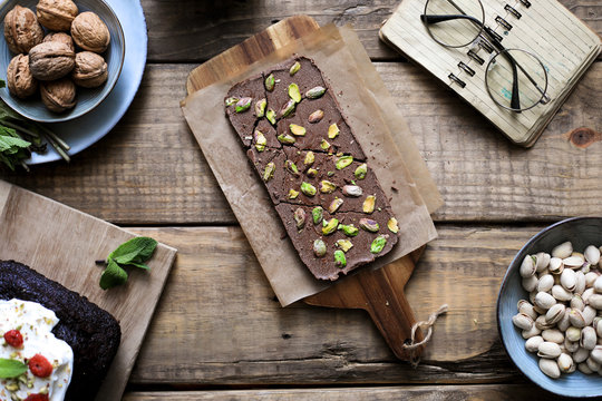 From above served tasty chocolate dessert garnished with pistachios on baking paper on wooden table